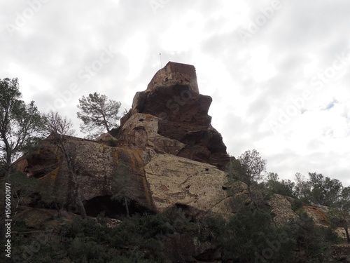 ermita de San Ramón luchando contra las fuerzas gravitatorias sobre un montículo rocoso, arquitectura popular, fachada blanca para que los marineros la pudiesen ver, Montroig. Tarragona, España   