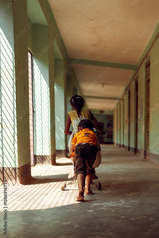 Fototapeta premium Children riding a bicycle down a long corridor
