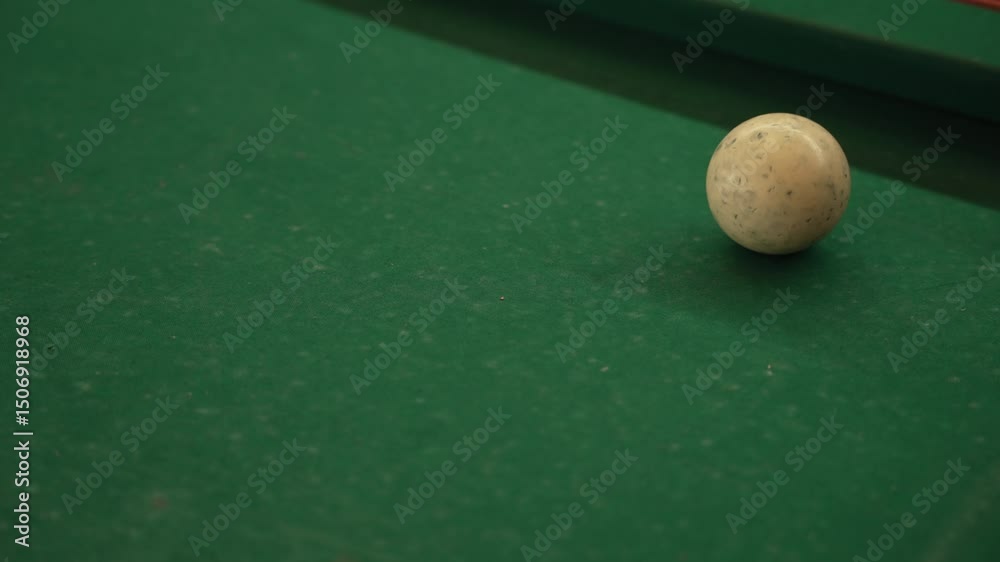 cue stick approaches white ball on green billiard table just before striking