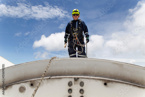 Engineer performing maintenance on top of a wind turbine nacelle outdoors