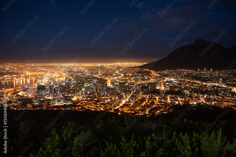 Fototapeta premium Cape Town glowing at night seen from Signal Hill with Table Mountain in the background