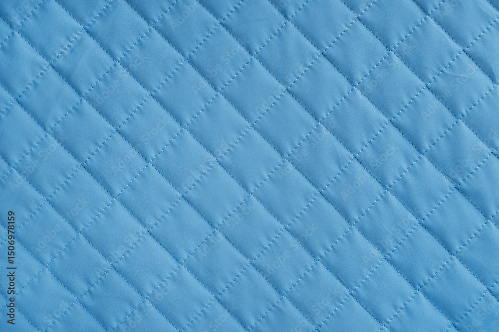 Fototapeta premium Checkered, diamond stitching pattern, blue quilted fabric background. Blanket or puffer jacket, stitch rhombus texture close up, macro. Wallpaper, backdrop.