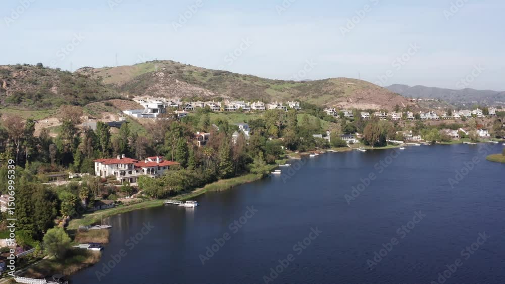 Wide aerial dolly shot of lakefront homes along in the exclusive community of Lake Sherwood, California. 4K at 30 FPS Wide aerial dolly shot of lakefront homes along in the exclusive community of Lake Sherwood, California. 4K at 30 FPS
