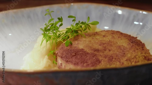 4K. The cook puts a cutlet with mashed potatoes on a plate.