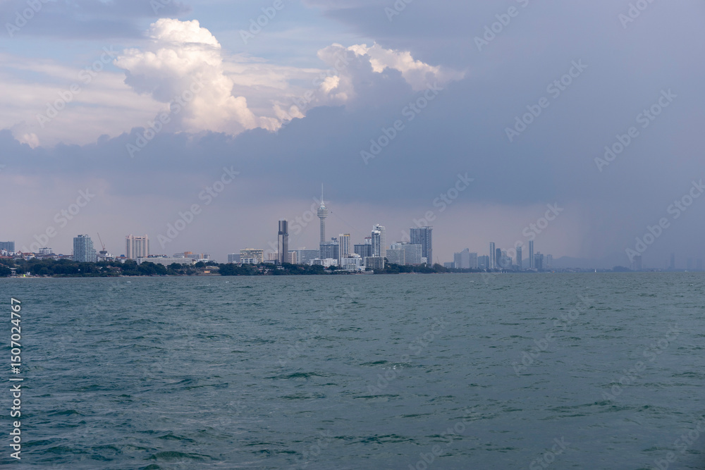 Naklejka premium Thailand.Pattaya. View of the city in cloudy weather from the ship at a distance from the shore