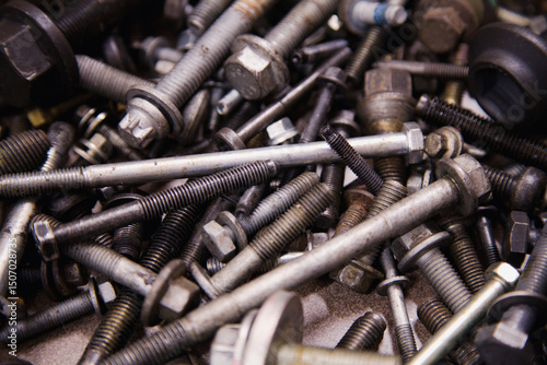 A textured backdrop of assorted bolts and screws in varied sizes, scattered randomly
