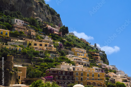 Explore the stunning cliffside village of Positano in Amalfi Coast Italy, featuring colorful buildings nestled against the dramatic mountains and lush greenery.