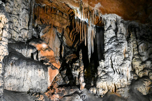 Interior of cave decorated with stalactite. Stone and rock formations in cave. Mineral and crystal formations. Speleology.