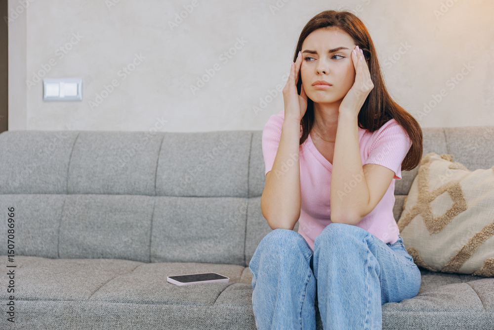 Obraz premium Young Woman Suffering From Headache While Sitting on Sofa at Home
