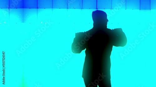 A silhouetted man dances outside by a disco-like light wall.  	