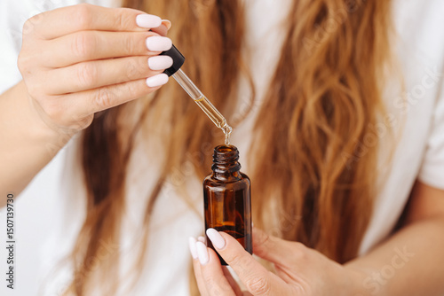 Wallpaper Mural Woman using cosmetic serum. Pipette with skincare oil. Natural beauty routine. Argan oil treatment. Female hands holding dropper bottle. Daily face care. Moisturizing essence for skin glow. Torontodigital.ca