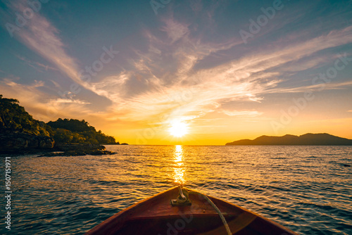 Fototapeta Naklejka Na Ścianę i Meble -  View from a red boat in the indigo ocean in the evening with twilight. There are many islands and a clear blue sky. Feeling fresh and relaxed. Ideas for a traveling background with copy space.