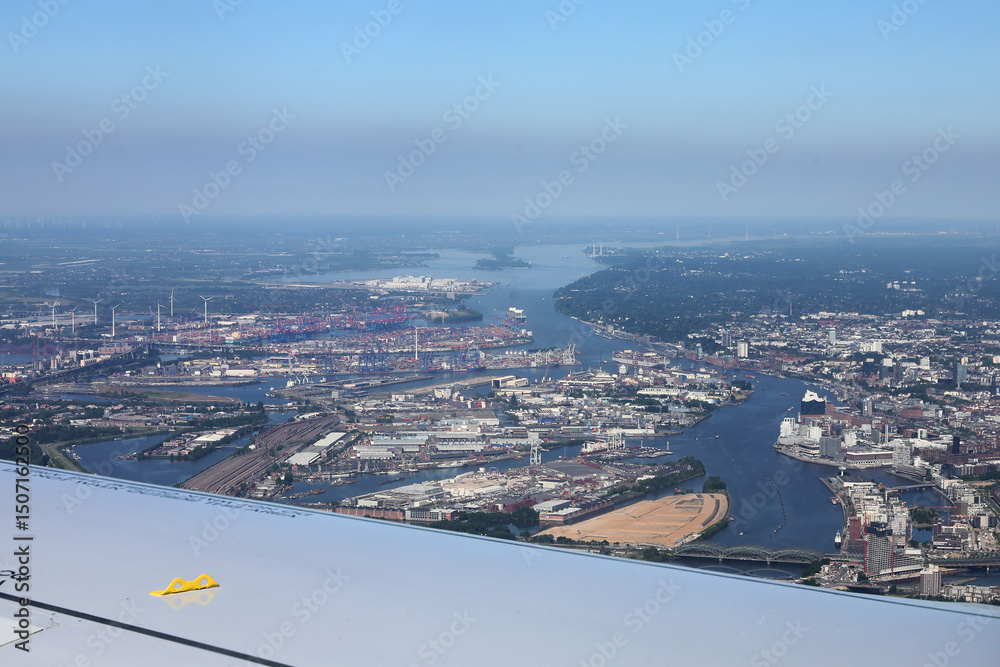 Fototapeta premium The industrial area of ​​the port of Hamburg photographed from a passenger plane landing at Hamburg International Airport. Selective focus.