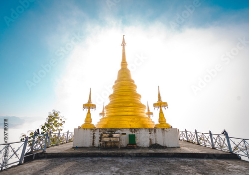 Fotografía Golden yellow pagoda on a white cement base on a high hill