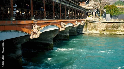 The traditional architecture Bridge, gracefully arching over the vibrant turquoise waters of the river. a landmark for tourist. About Dujiangyan Irrigation System in China 