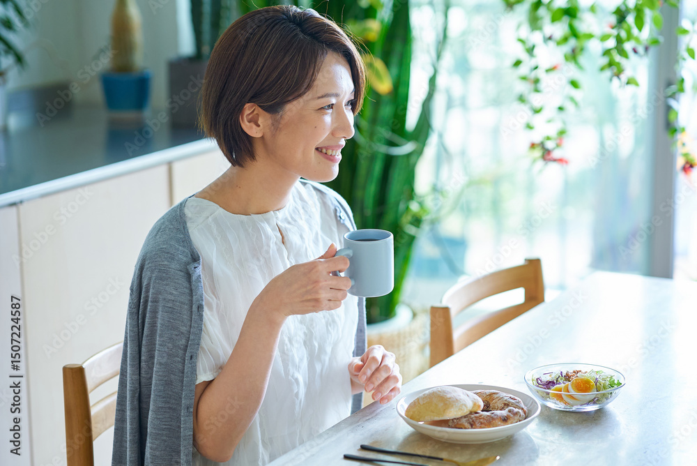 部屋で朝食を食べる女性 部屋で朝食を食べる女性