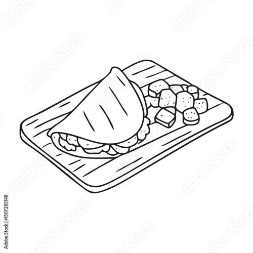 A tortilla folded beside grilled meat on a wooden tray