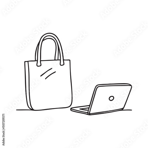 A tote bag lying next to a laptop on the floor
