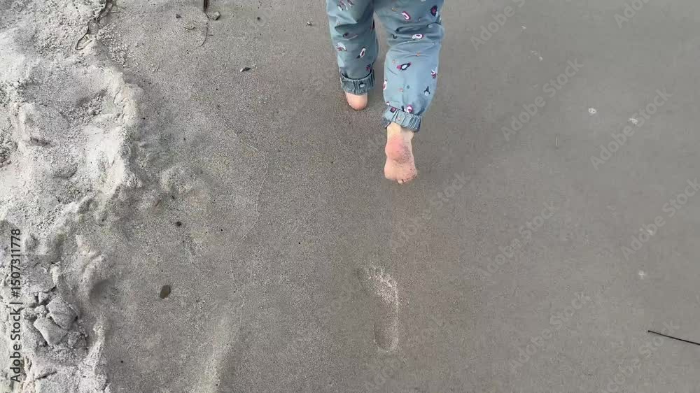 Child's barefoot adventures: exploring the wet sands of Graal-Müritz beach.