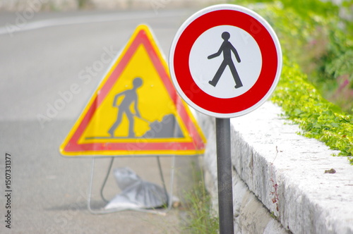 Construction zone sign is next to a pedestrian crossing sign