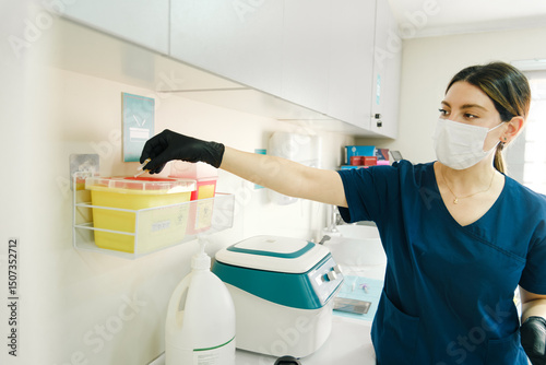 Dentist disposing medical waste into yellow safety container
