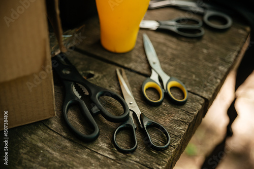 Various scissors lie on a wooden table