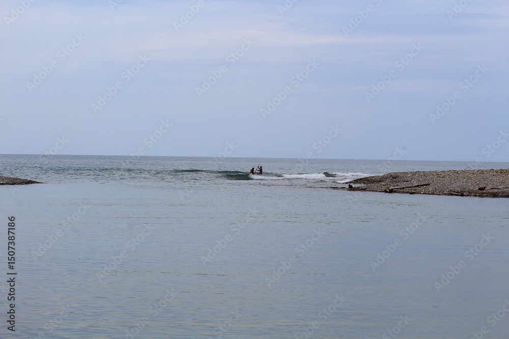 two people are paddle boarding on the black sea in the evening two people are paddle boarding on the black sea in the evening