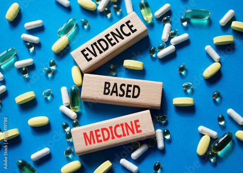 Evidence Based Medicine symbol. Concept word Evidence Based Medicine on wooden blocks. Beautiful blue background with pills. Medicine and Evidence Based Medicine concept. Copy space