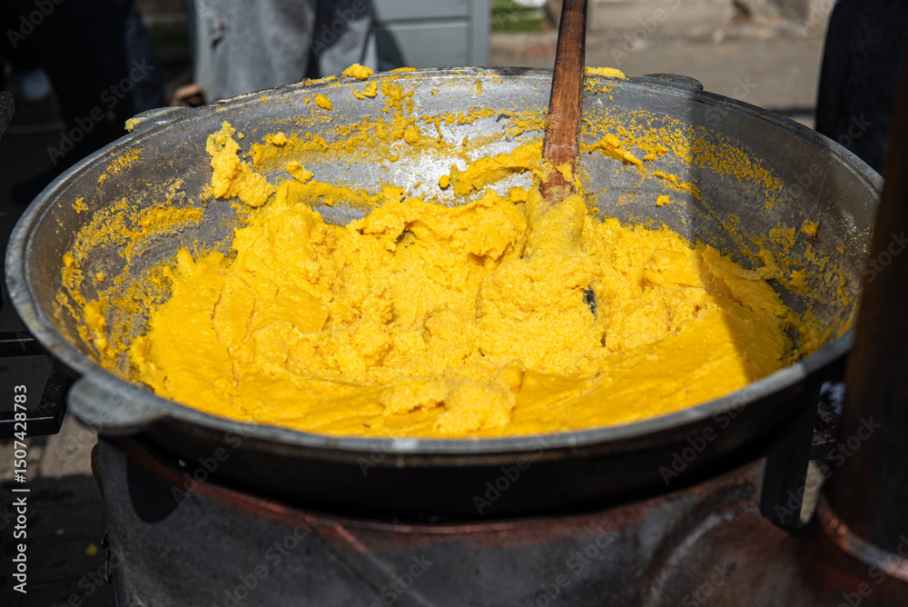 Traditional Moldovan and Romanian mamaliga cornmeal porridge in large pot at outdoor festival