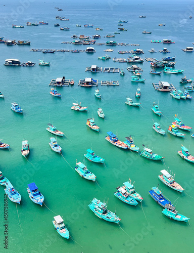 Top view of many fishing boats anchored in the turquoise sea. Best place for fishing and relaxing in Phu Quoc Island, Vietnam.