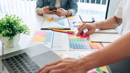 Two creative graphic designer team working on color selection and drawing on graphic tablet, Color swatch samples chart for selection coloring in inspiration to creativity at workplace