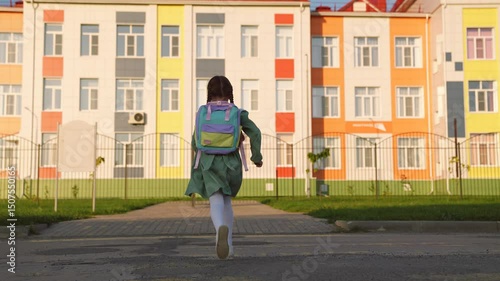 Wallpaper Mural little girl with school backpack runs with her feet way to school. child daughter hurries knowledge lesson. heavy school bag shoulders running kid child. school childhood. children running outdoors. Torontodigital.ca