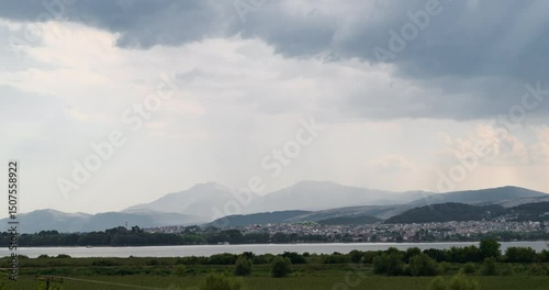 Time lapse. Panoramic view of the town of Ioannina, the lake in front of it and the mountains behind it during a developing summer storm