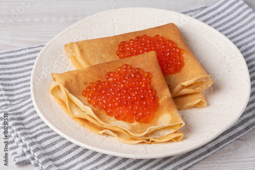 Freshly baked pancakes with red caviar