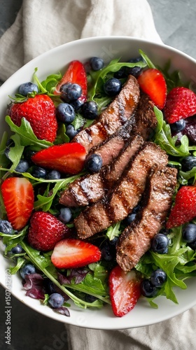 Grilled Steak Salad With Fresh Strawberries and Blueberries in a Bowl