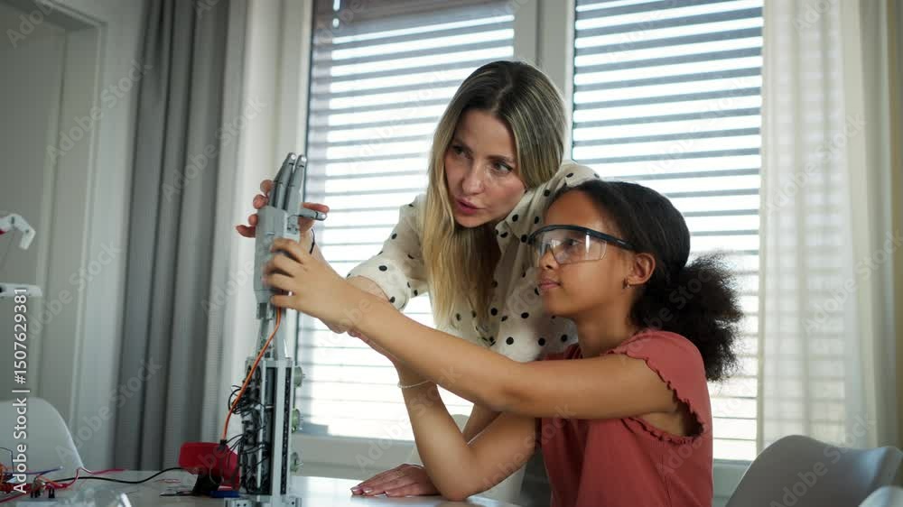 Mom teaching daughter robotics and inspiring interest in STEM.