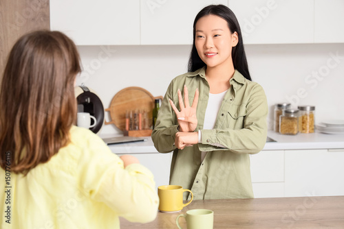 Young mute women using sign language at home photo