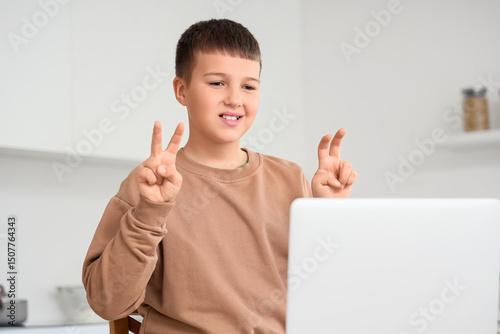 Mute boy using sign language during video call at home photo