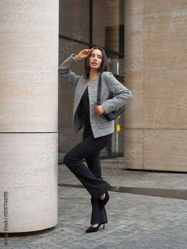 Stylish woman poses confidently in casual streetstyle during day in urban setting