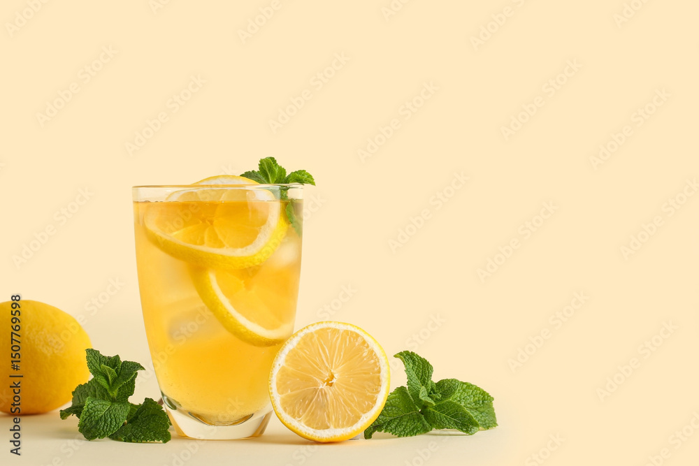 Fototapeta premium Glass of lemon ice tea with mint on beige background