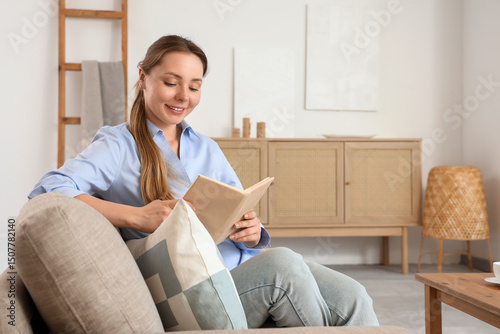 Smiling young woman reading...