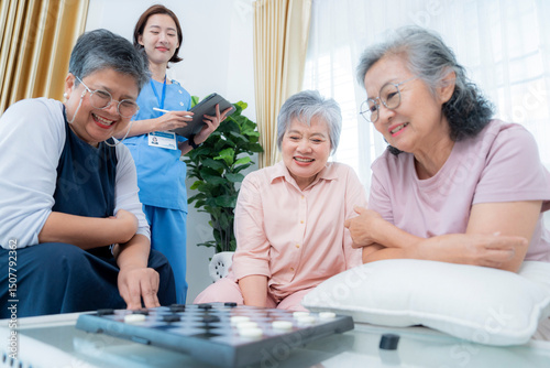 A group of elderly women enjoy a board game together, fostering social interaction and mental stimulation. A healthcare worker stands nearby, ensuring a supportive and healthy environment for senior.