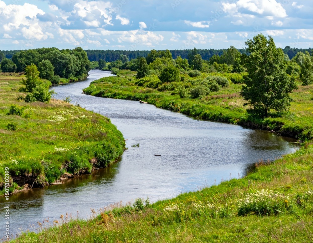 Obraz premium Serene River Flowing Through Lush Green Fields Under Bright Sky