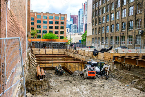 deep foundation excavation at downtown construction site  in toronto with machinery and butressing 