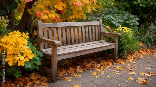 Weathered wooden bench in peaceful garden surrounded by vibrant autumn leaves creates serene atmosphere, inviting relaxation and reflection amidst nature beauty