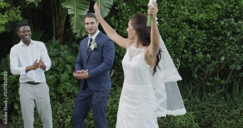 Bride tossing bridal bouquet for tradition at garden, groom cheering, guest catching it, copy space