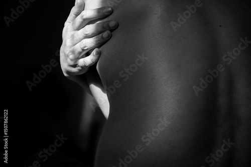 Hand Embracing Bare Back in Intimate Monochrome Photography