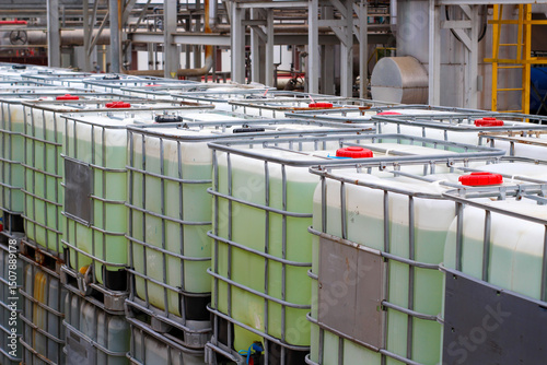 Stacked IBC totes, industrial chemical storage, outdoor setting	