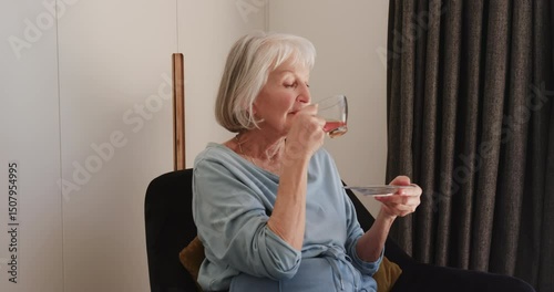 Senior woman enjoying tea peacefully at home, embracing quiet solitude