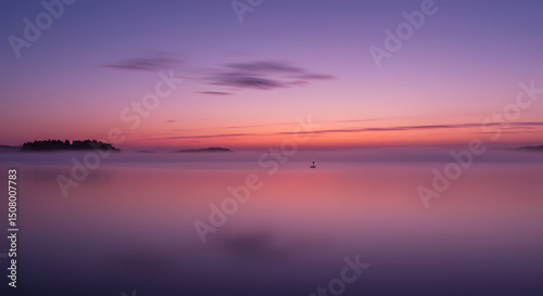 Serene Misty Sunrise over Calm Water with Island Silhouette Peaceful Dawn Landscape